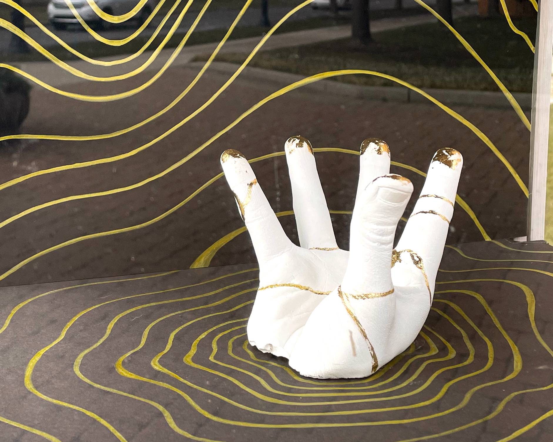 plaster hand sculpture on black background